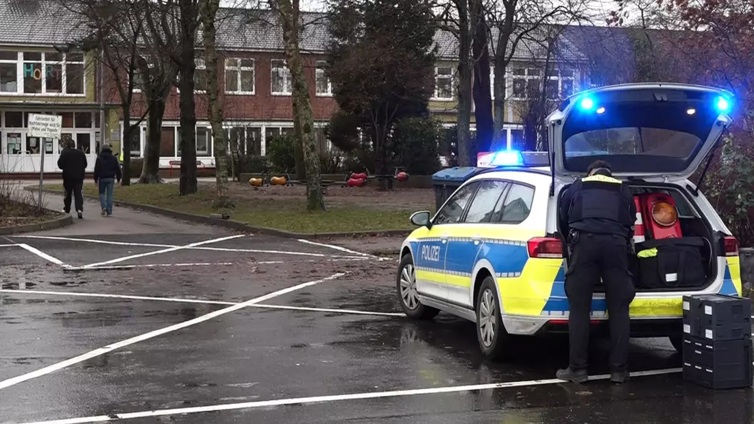 Ein Polizeiauto steht vor dem Gebäude einer  Grund- und Hauptschule in Lüdingworth. Dort hat ein Mädchen ein anderes mit einem Messer schwer verletzt. - Bild: -/Nord-West-Media TV/dpa