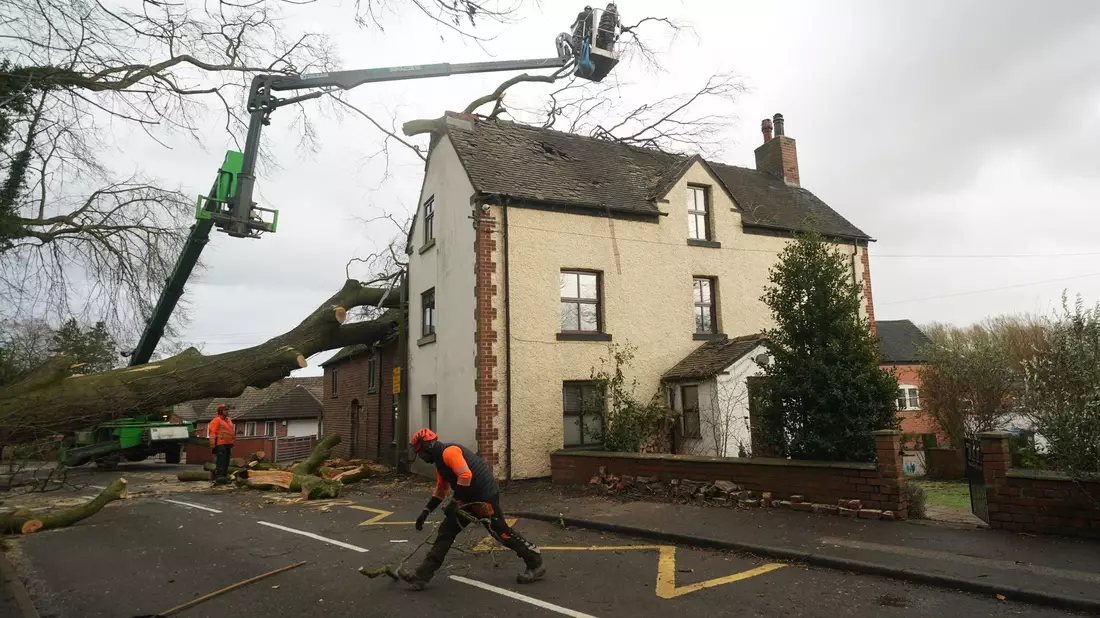 Arbeiter entfernen einen umgestürzten Baum, der das Dach eines Hauses in Derbyshire beschädigt hat. - Bild: Jacob King/PA Wire/dpa