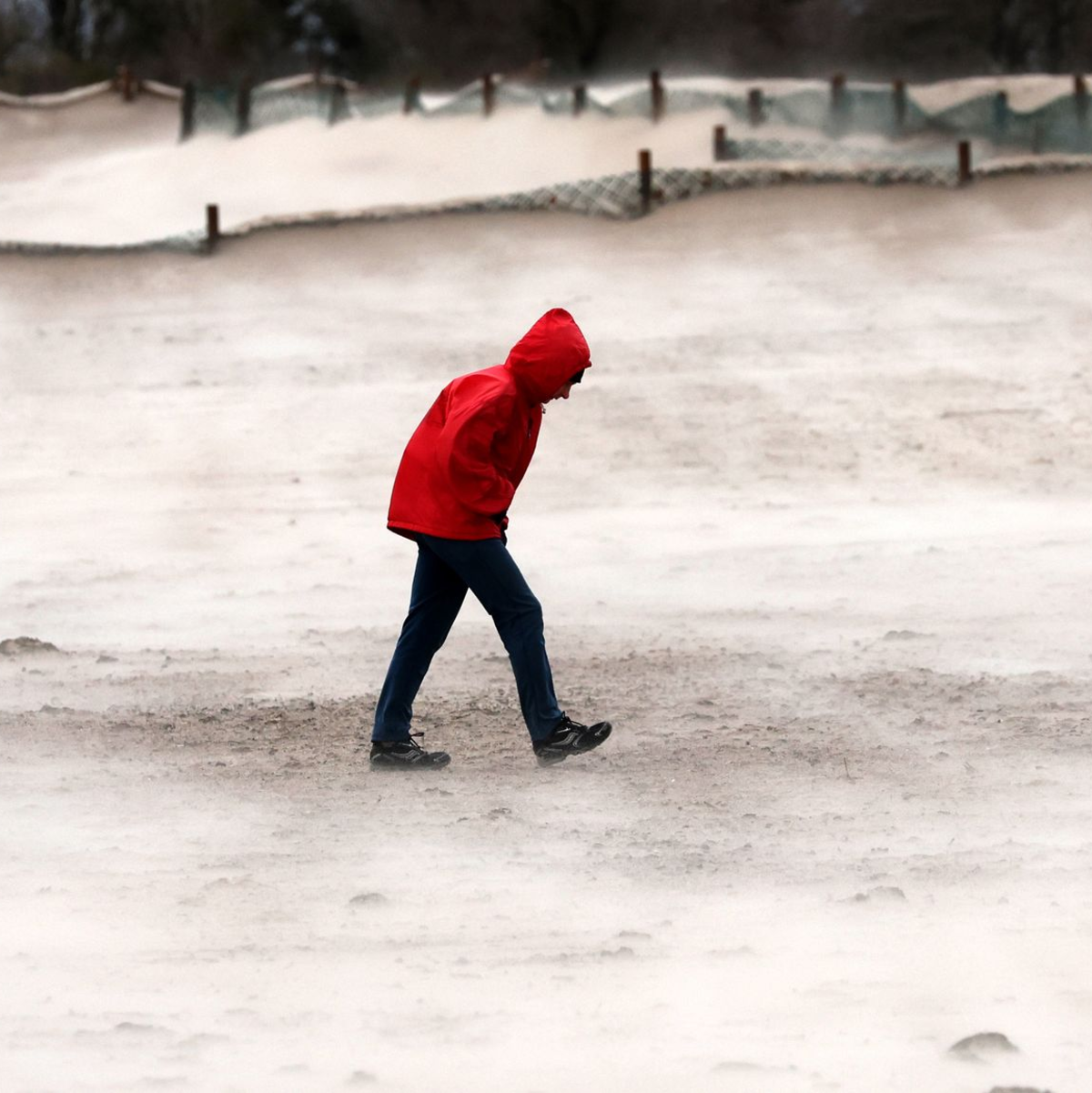Ein Mann geht im Sturm am Ostseestrand von Warnemünde entlang. - Foto: Bernd Wüstneck/dpa