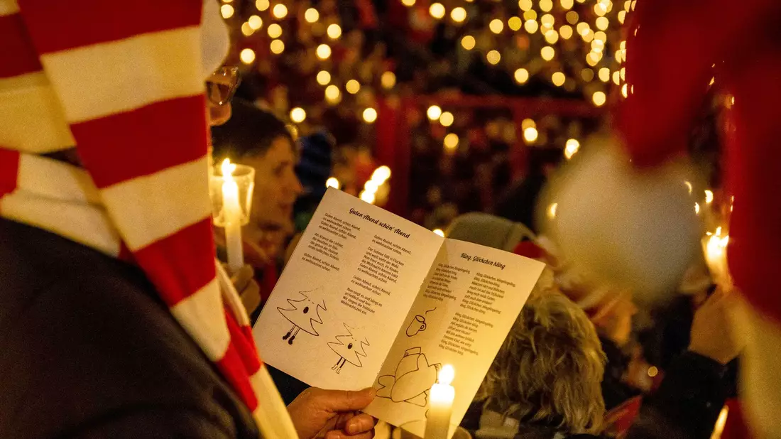 Tausende Menschen nehmen am Weihnachtssingen im Stadion An der Alten Försterei in Berlin teil. - Bild: Christophe Gateau/dpa