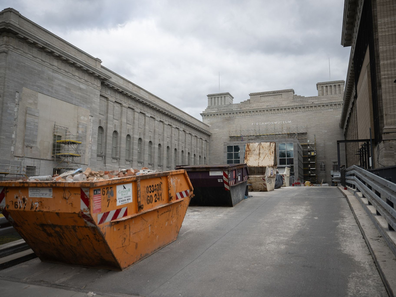 Container mit Bauschutt stehen am Pergamonmuseum in Berlin: Die Sanierungsarbeiten laufen. - Foto: Sebastian Christoph Gollnow/dpa