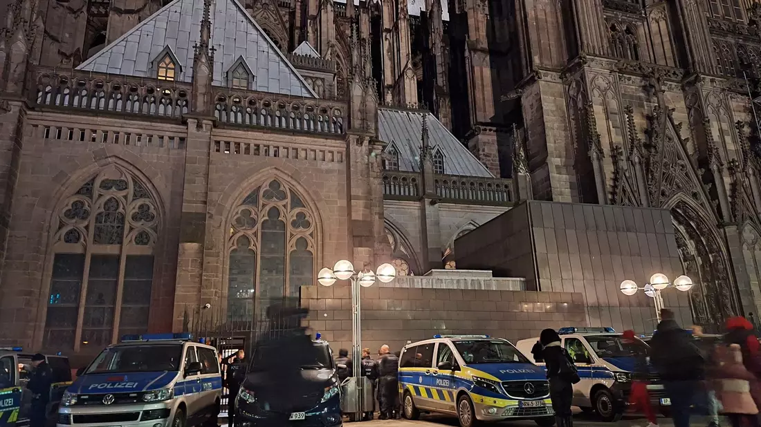 Einsatzfahrzeuge der Polizei stehen vor dem Kölner Dom. - Bild: Sascha Thelen/dpa