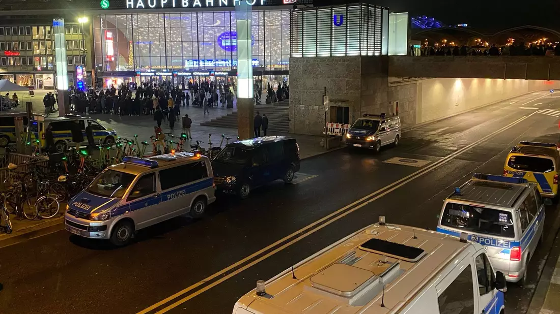 Polizisten und Einsatzfahrzeuge der Polizei stehen vor dem Hauptbahnhof unweit vom Dom. - Bild: Vincent Kempf/dpa