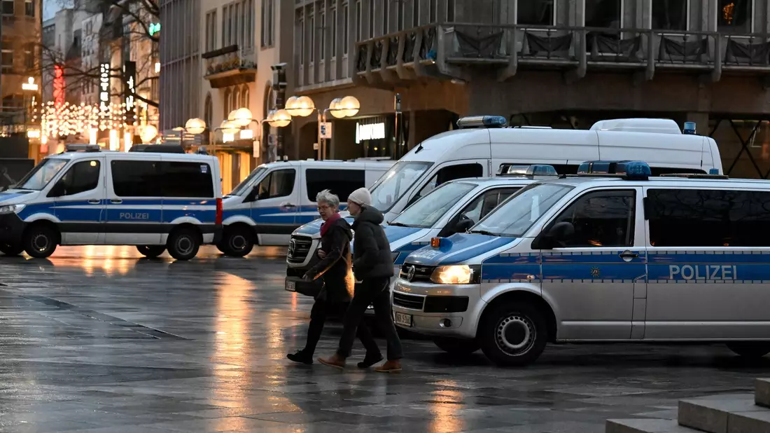 Polizisten kontrollieren am Eingang des Kölner Doms den Beginn der Frühmesse am Weihnachtstag. - Bild: Roberto Pfeil/dpa
