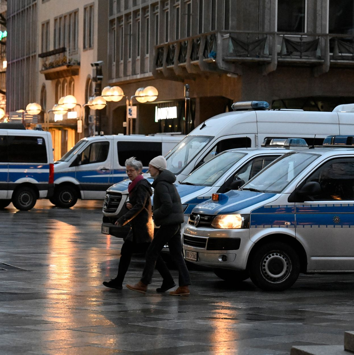 Polizisten kontrollieren am Eingang des Kölner Doms den Beginn der Frühmesse am Weihnachtstag. - Foto: Roberto Pfeil/dpa