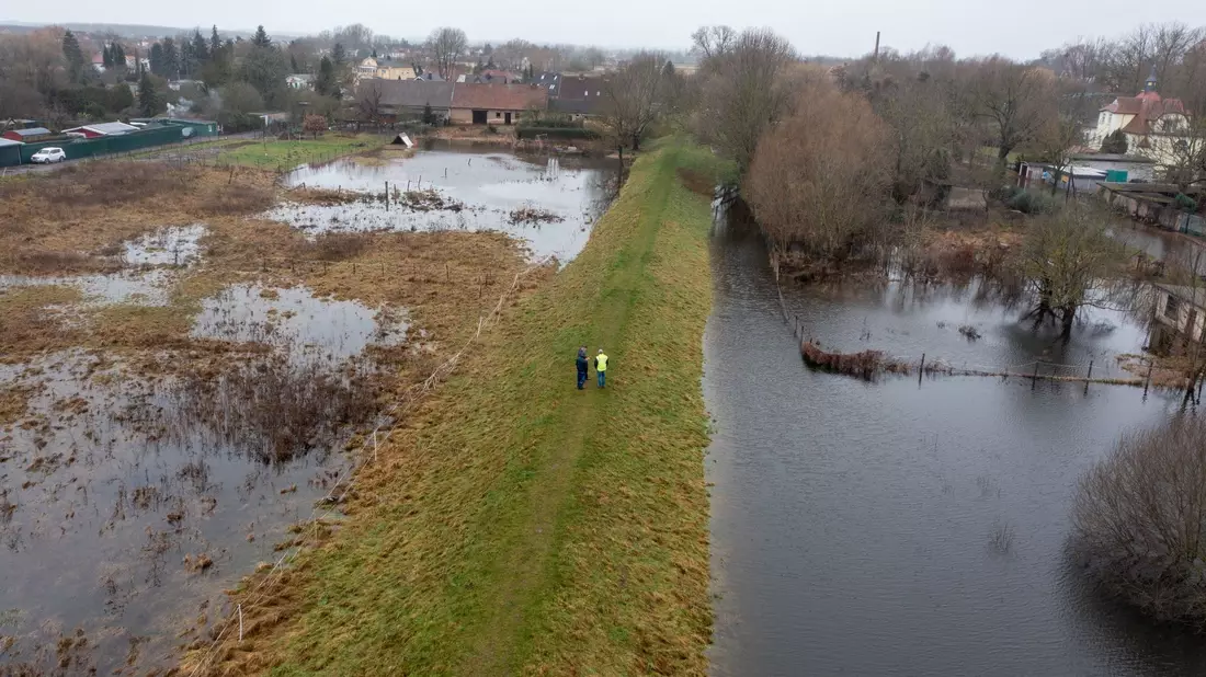 Mitarbeiter des Landesbetriebs für Hochwasserschutz in Wolmerstedt in Sachsen-Anhalt laufen einen Deich ab. - Bild: Stephan Schulz/dpa