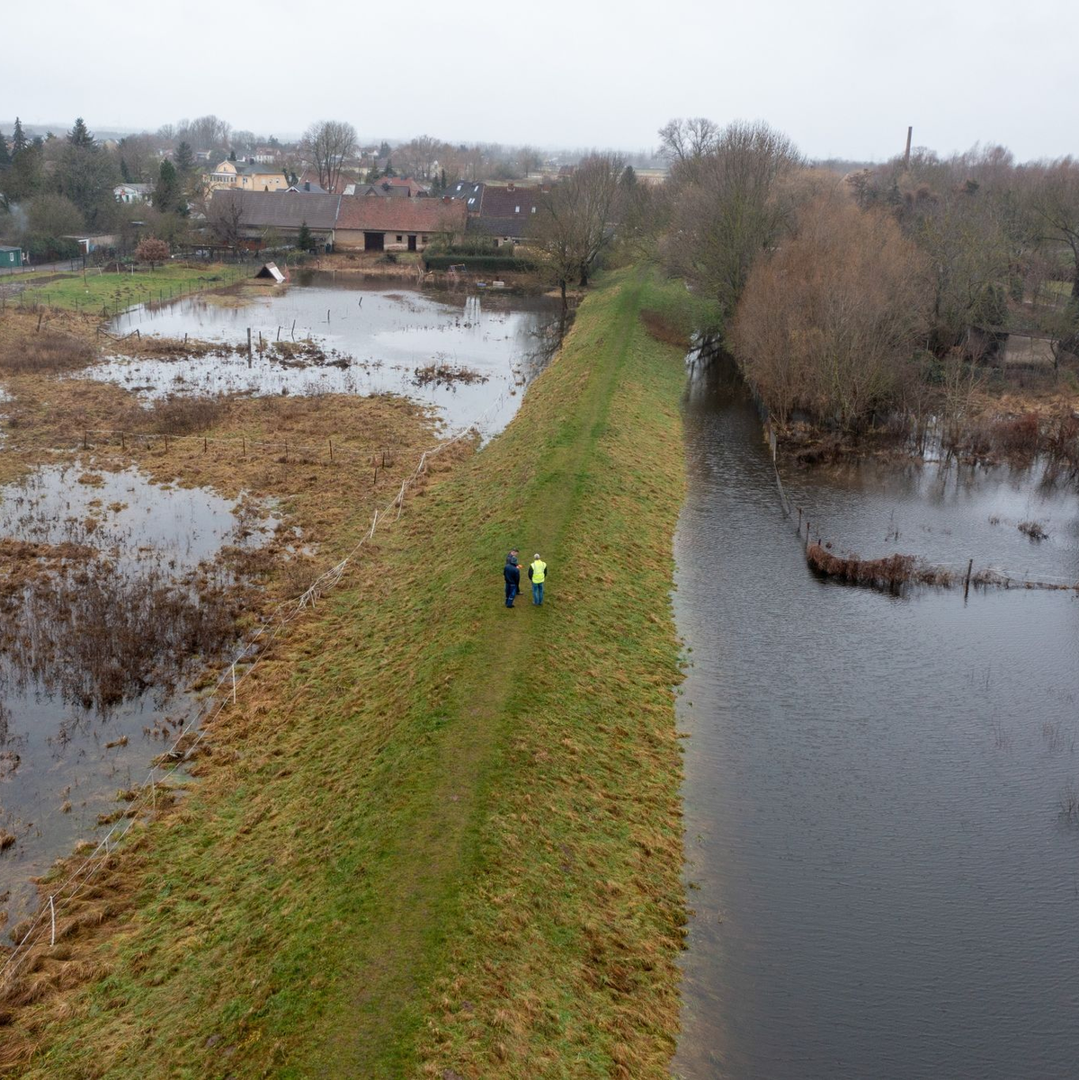 Mitarbeiter des Landesbetriebs für Hochwasserschutz in Wolmerstedt in Sachsen-Anhalt laufen einen Deich ab. - Foto: Stephan Schulz/dpa