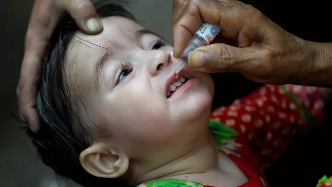 Ein Gesundheitshelfer verabreicht einem Kind einen Polio-Impfstoff. - Bild: K.M. Chaudary/AP/dpa