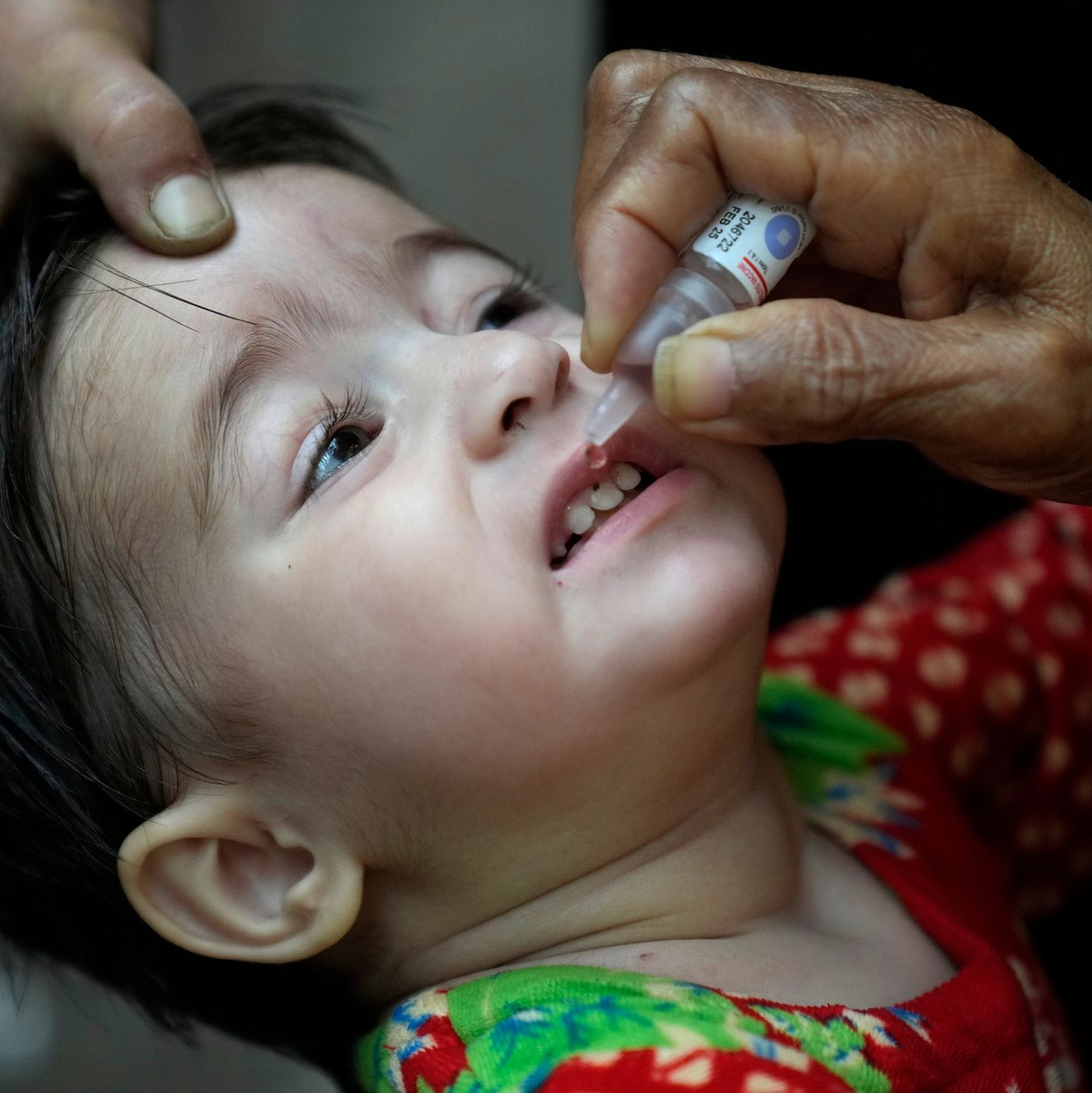 Ein Gesundheitshelfer verabreicht einem Kind einen Polio-Impfstoff. - Foto: K.M. Chaudary/AP/dpa