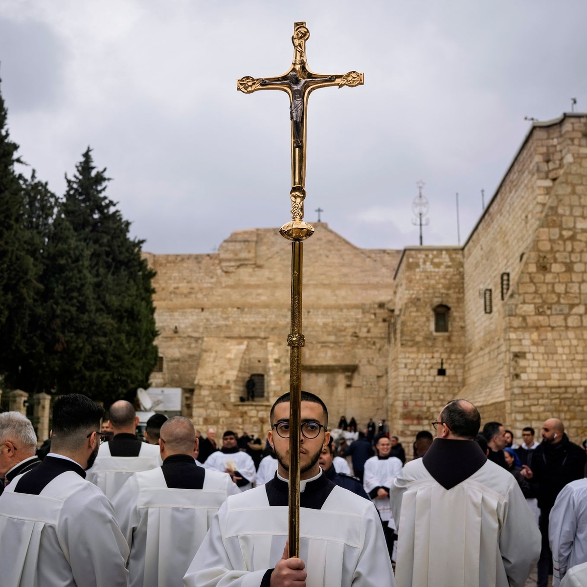 Katholische Geistliche gehen am Heiligabend in Bethlehem im Westjordanland in einer Prozession neben der Geburtskirche. - Foto: Leo Correa/AP/dpa