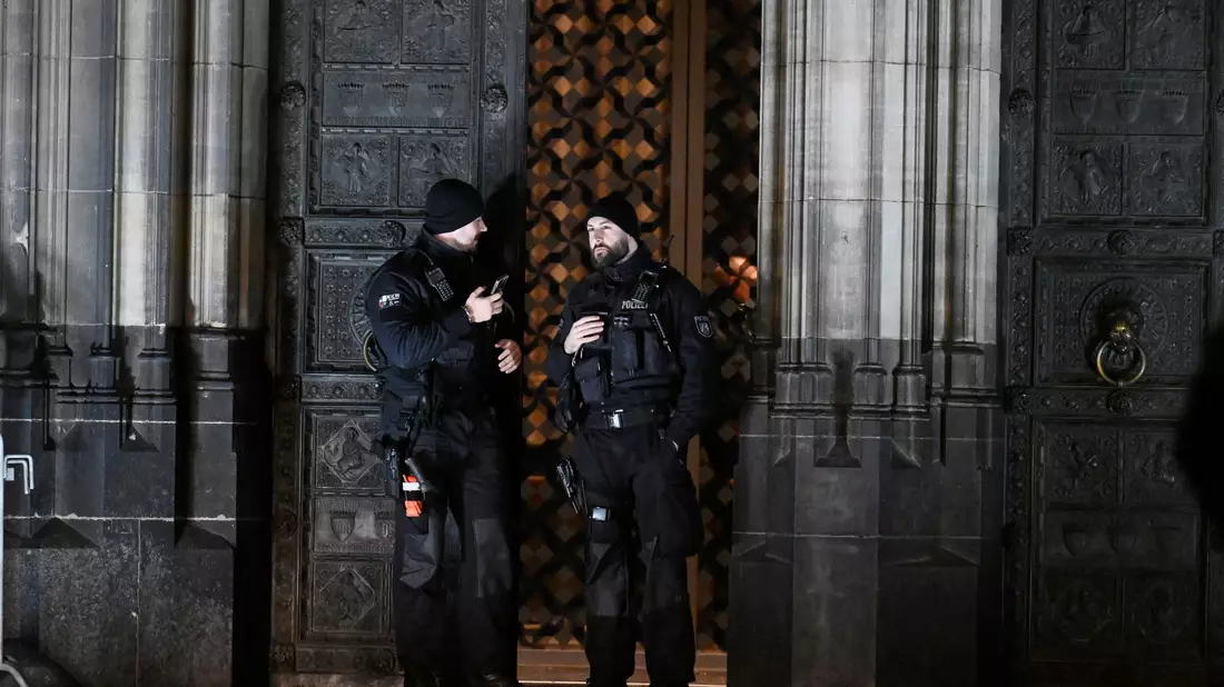 Polizisten sichern einen Eingang zum Kölner Dom. - Bild: Roberto Pfeil/dpa
