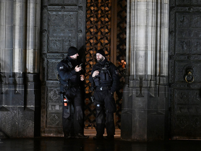 Polizisten sichern einen Eingang zum Kölner Dom. - Foto: Roberto Pfeil/dpa