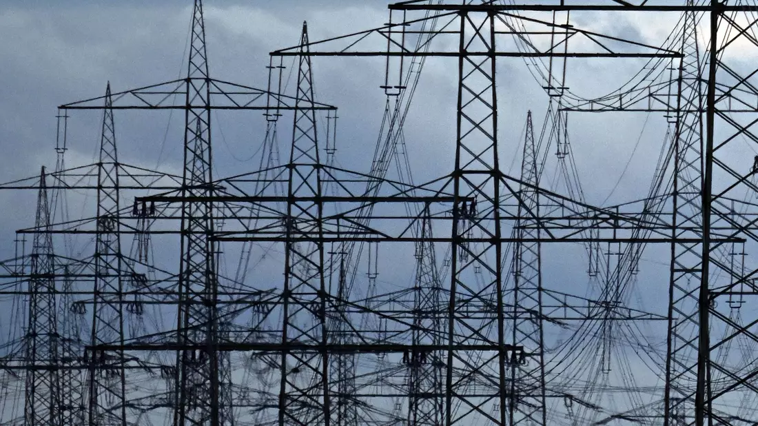 Strommasten auf einem Acker. «Die Zeit der billigen Energie ist vorbei», meint Netzagenturchef Müller. - Bild: Federico Gambarini/dpa