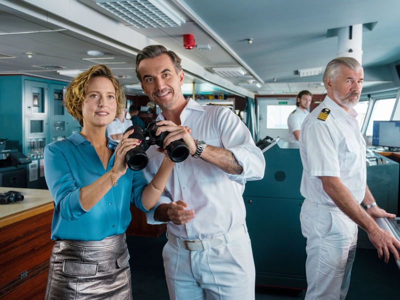 Kapitän Max Parger (Florian Silbereisen, M.) bringt zur Überraschung seines Staff-Kapitäns Martin Grimm (Daniel Morgenroth, r.) Veronika Bruckner (Wanda Perdelwitz) mit an Bord. - Foto: Dirk Bartling/ZDF/dpa