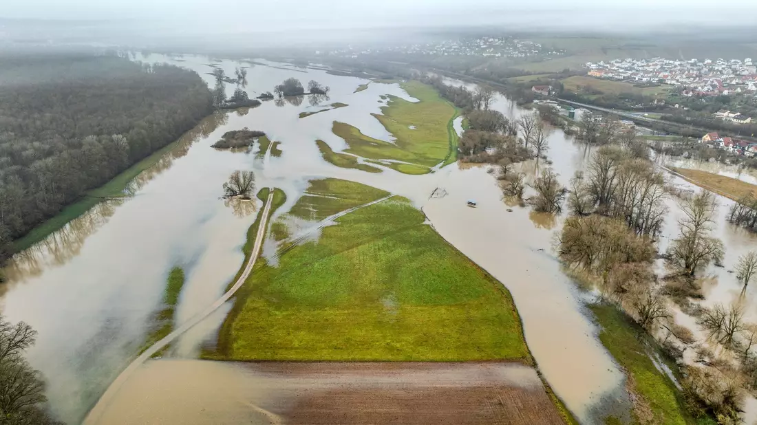 Der über die Ufer getretene Main überflutet Wiesen und Felder bei Haßfurt. - Bild: René Ruprecht/dpa