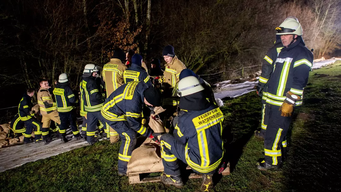 Einsatzkräfte des Technischen Hilfswerks (THW) laden in Oldenburg zahlreiche Sandsäcke ab. Ein mobiler Deich soll die Wohngebiete im Stadtteil Bümmerstede vor einem drohenden Hochwasser schützen. - Bild: Hauke-Christian Dittrich/dpa
