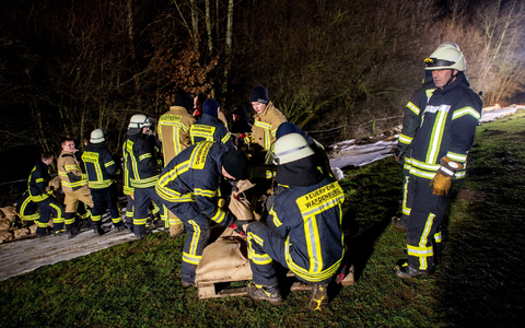Einsatzkräfte des Technischen Hilfswerks (THW) laden in Oldenburg zahlreiche Sandsäcke ab. Ein mobiler Deich soll die Wohngebiete im Stadtteil Bümmerstede vor einem drohenden Hochwasser schützen. - Foto: Hauke-Christian Dittrich/dpa