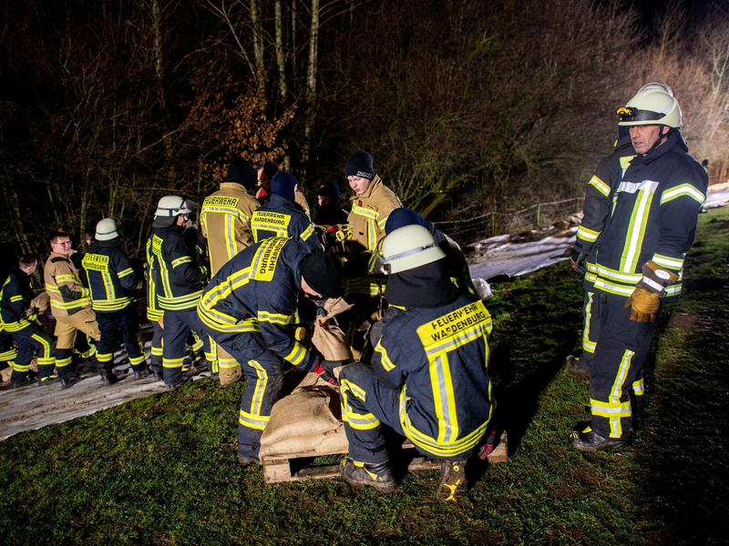 Einsatzkräfte der Feuerwehr sichern den aufgeweichten Deich der Hunte nahe der Ortschaft Astrup mit Vlies und Sandsäcken. - Foto: Hauke-Christian Dittrich/dpa