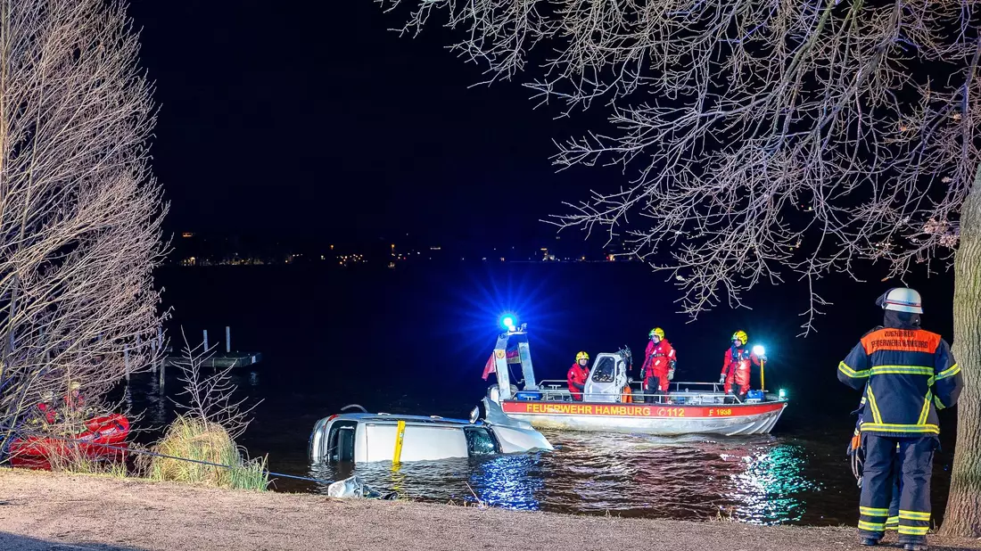 Einsatzkräfte der Feuerwehr bergen das Auto aus der Außenalster. - Bild: Schröder/News5/dpa