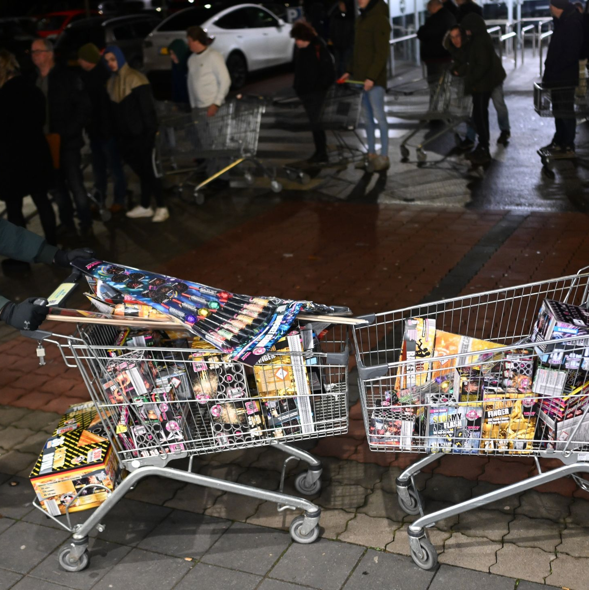 Junge Niederländer sind extra angereist, um zu Beginn des Verkaufs von Silvesterfeuerwerk bei einem Discounter in der Grenzregion deutsches Feuerwerk einzukaufen. - Foto: Lars Penning/dpa
