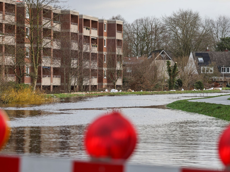 Sandsäcke liegen auf einem durchweichten Deich vor evakuierten Wohnhäusern in Lilienthal bei Bremen. - Foto: Focke Strangmann/dpa