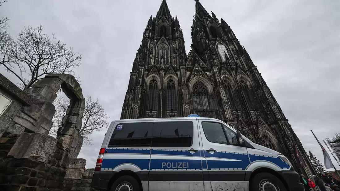 Ein Polizeifahrzeug steht vor dem Kölner Dom. - Bild: Oliver Berg/dpa
