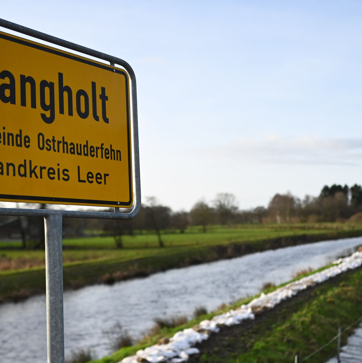Sandsäcke ligen am Fluss Burlage-Langholter Tief, einem Nebenfluss der Leda. Dort hat sich die Lage momentan etwas entspannt. - Foto: Lars Penning/dpa