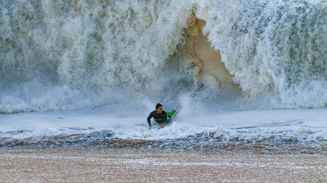 Ein Surfer taucht in Seal Beach aus den Wellen auf. - Bild: Damian Dovarganes/AP
