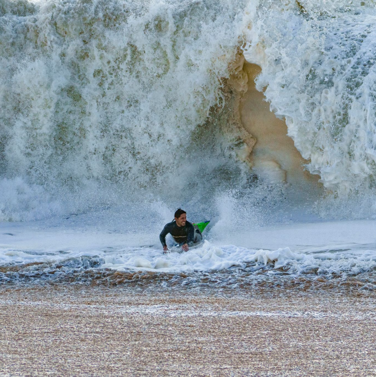 Ein Surfer taucht in Seal Beach aus den Wellen auf. - Foto: Damian Dovarganes/AP