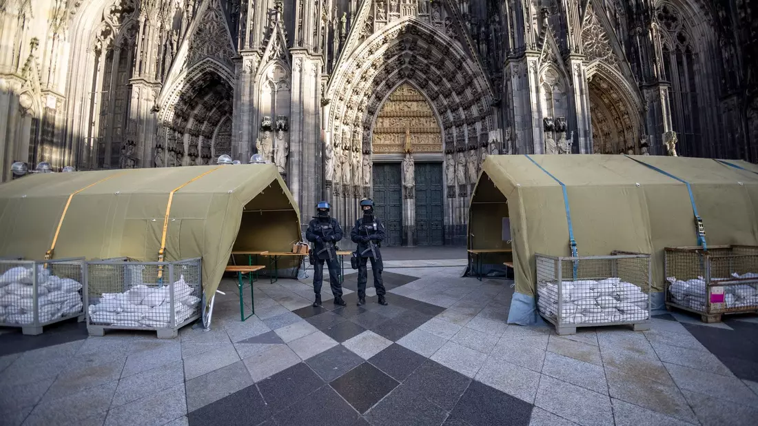 Polizisten mit Maschinenpistolen stehen vor dem Kölner Dom. Nach dem Terroralarm für das Gotteshaus sind drei weitere Verdächtige festgesetzt worden. - Bild: Thomas Banneyer/dpa