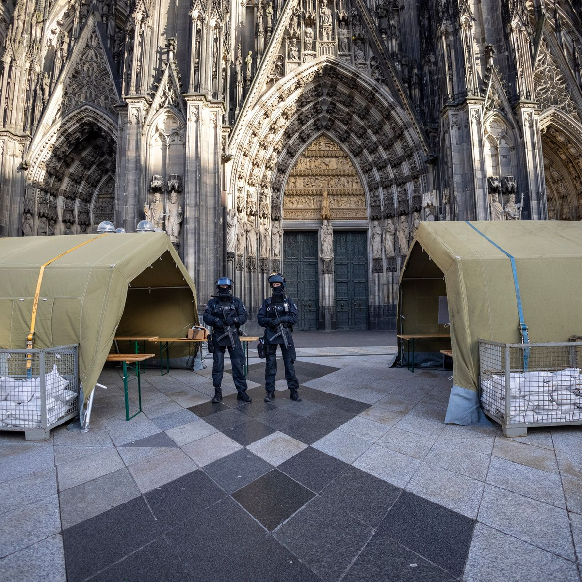Polizisten mit Maschinenpistolen stehen vor dem Kölner Dom. Nach dem Terroralarm für das Gotteshaus sind drei weitere Verdächtige festgesetzt worden. - Foto: Thomas Banneyer/dpa
