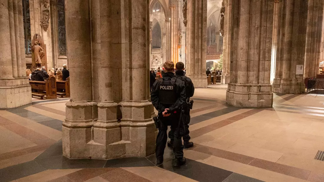 Polizeibeamte sichern während der Silvester-Messe den Kölner Dom. - Bild: Thomas Banneyer/dpa