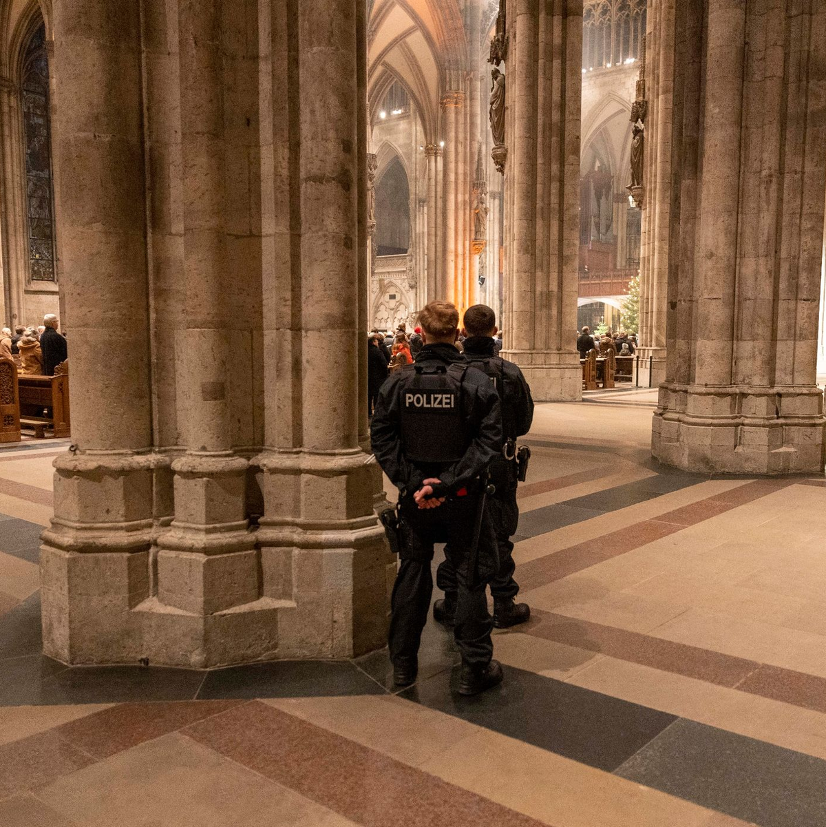 Polizeibeamte sichern während der Silvester-Messe den Kölner Dom. - Foto: Thomas Banneyer/dpa