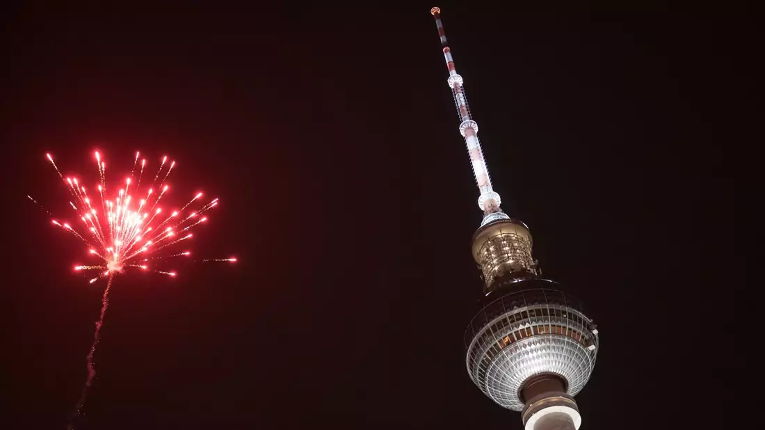 Eine Rakete explodiert in der Silvesternacht in der Nähe des Berliner Fernsehturms. - Bild: Sebastian Christoph Gollnow/dpa