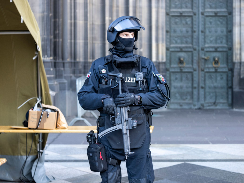 Vor dem Pontifikalamt im Kölner Dom zum Jahresabschluss mit Kardinal Woelki wird das Domumfeld von Einsatzkräften der Polizei mit Maschinenpistolen stark bewacht. - Foto: Thomas Banneyer/dpa