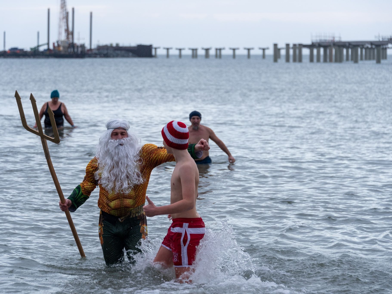 Als Neptun verkleidet steigt Tim Bergelt zusammen mit anderen Hobbyschwimmern aus dem 5 Grad kalten Meer, hier die Ostsee. - Foto: Stephan Schulz/dpa