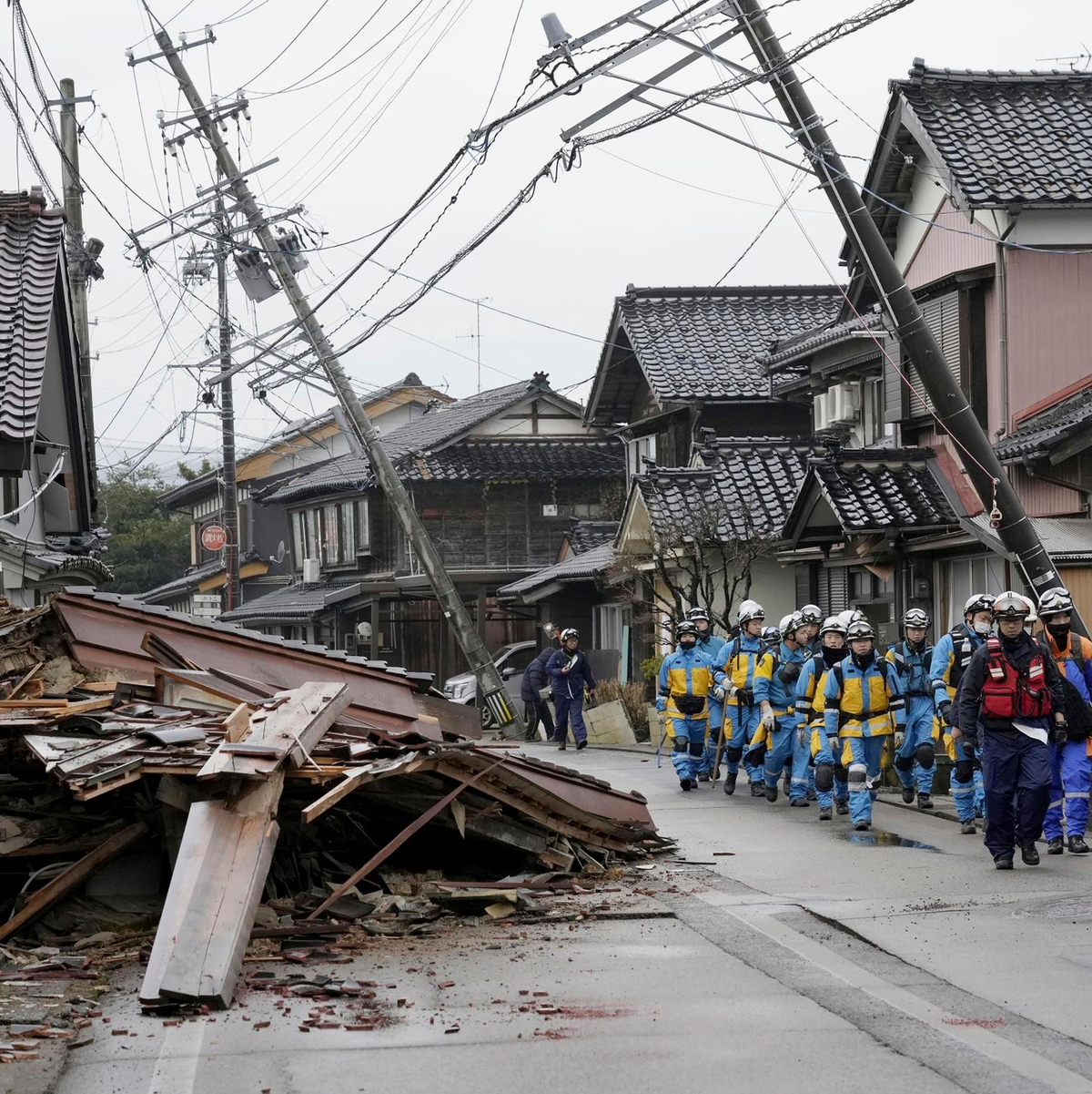 Polizisten gehen an eingestürzten Häusern vorbei, die von den Erdbeben in Suzu, Präfektur Ishikawa getroffen wurden. - Foto: Uncredited/Kyodo News/AP/dpa