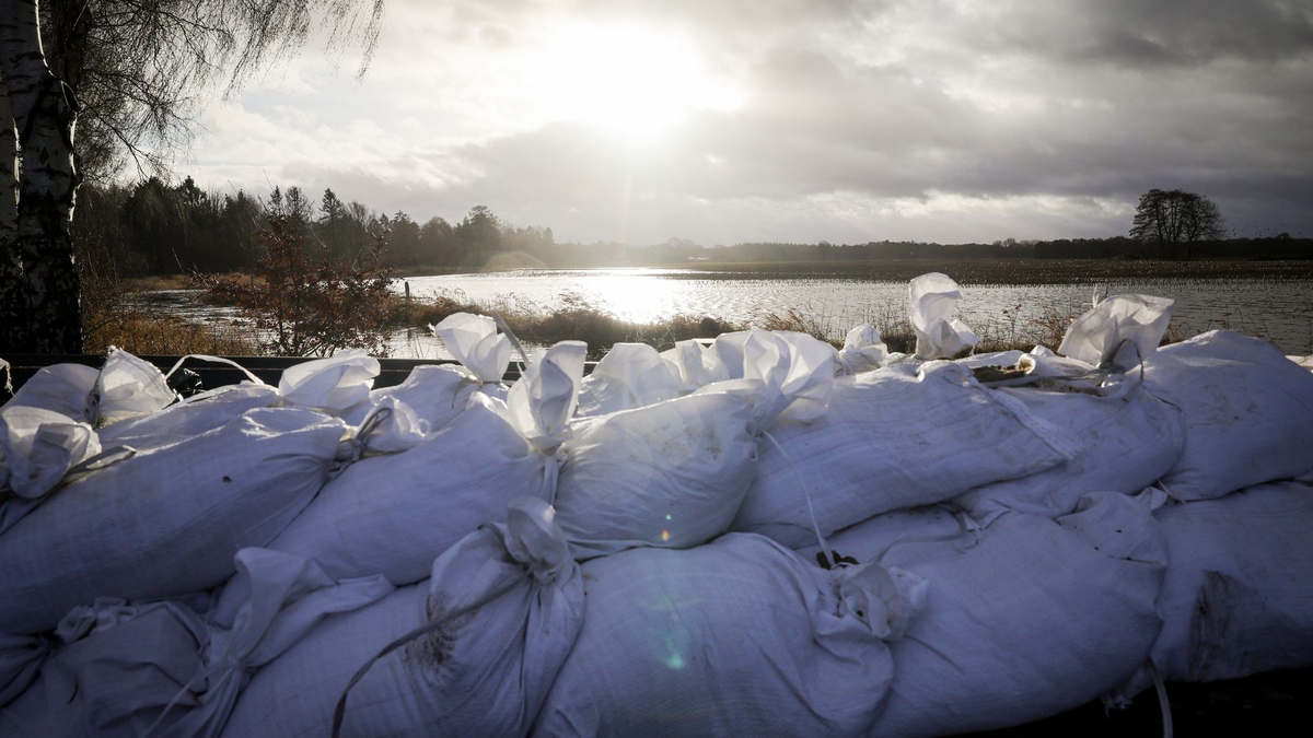 Sandsäcke an einer Landstraße am Ortseingang von Sandkrug bei Oldenburg. - Foto: Christian Charisius/dpa