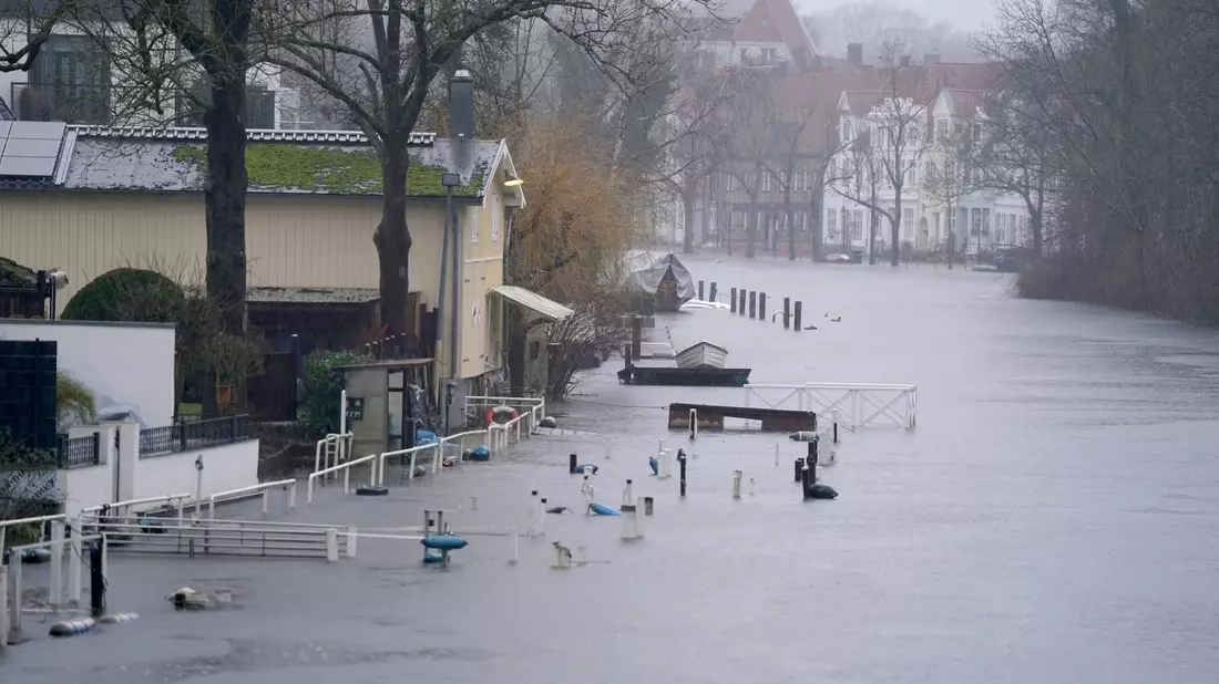 Gehwege und Bootsstege sind am Ufer der Trave in Lübeck vom Hochwasser umgeben. - Bild: Marcus Brandt/dpa
