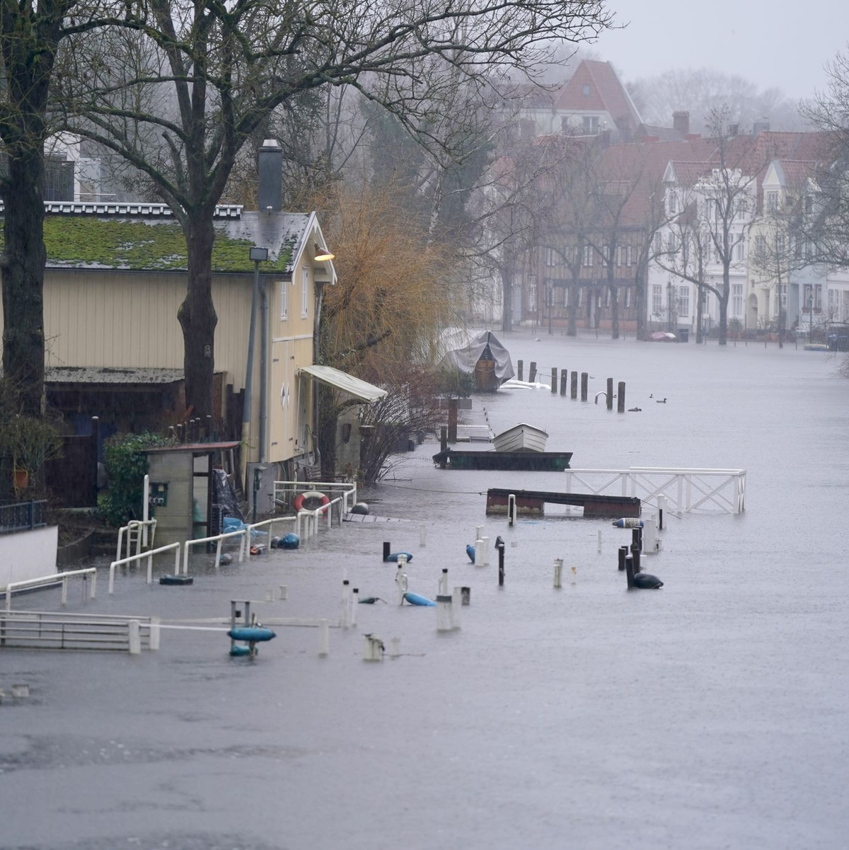 Gehwege und Bootsstege sind am Ufer der Trave in Lübeck vom Hochwasser umgeben. - Foto: Marcus Brandt/dpa