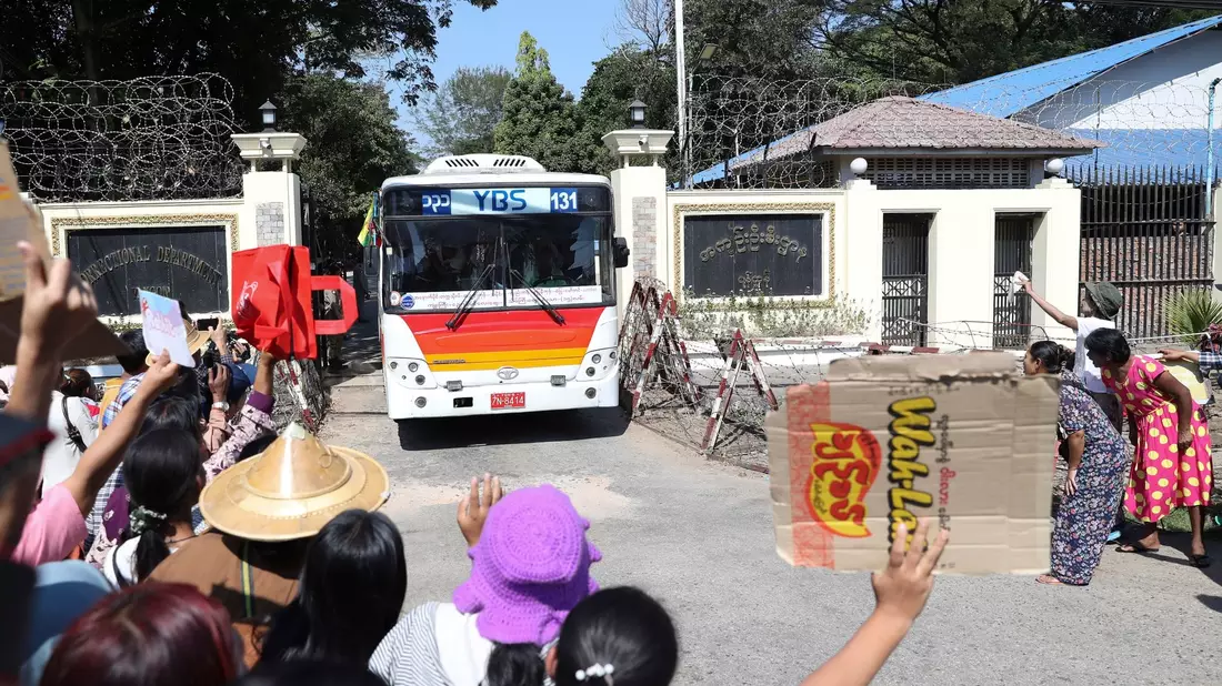 Familienmitglieder und Freunde von Häftlingen stehen vor dem Insein-Gefängnis in Yangon, als ein Bus mit Freigelassenen vom Gelände fährt. - Bild: Thein Zaw/AP/dpa