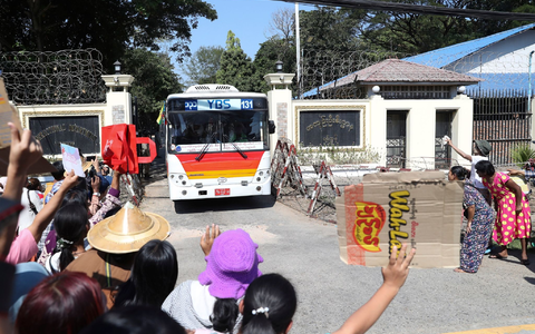 Familienmitglieder und Freunde von Häftlingen stehen vor dem Insein-Gefängnis in Yangon, als ein Bus mit Freigelassenen vom Gelände fährt. - Foto: Thein Zaw/AP/dpa