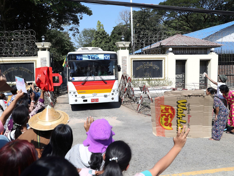 Familienmitglieder und Freunde von Häftlingen stehen vor dem Insein-Gefängnis in Yangon, als ein Bus mit Freigelassenen vom Gelände fährt. - Foto: Thein Zaw/AP/dpa