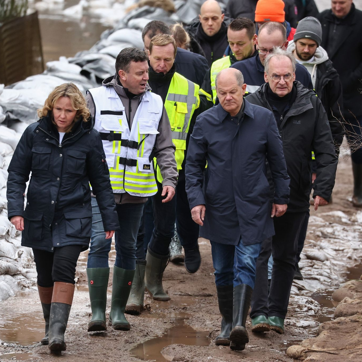 Bundeskanzler Olaf Scholz (vorne rechts) trägt bei seinem Besuch im Hochwassergebiet in Sangerhausen Gummistiefel. - Foto: Jan Woitas/dpa