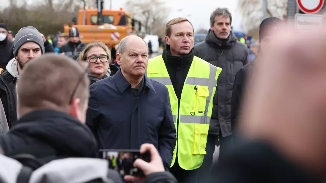 Kanzler Olaf Scholz zusammen mit dem Leiter des Katastrophenschutz Mansfeld-Südharz, Sven Vogler, im Gespräch mit Anwohnern in Sangerhausen. - Bild: Jan Woitas/dpa