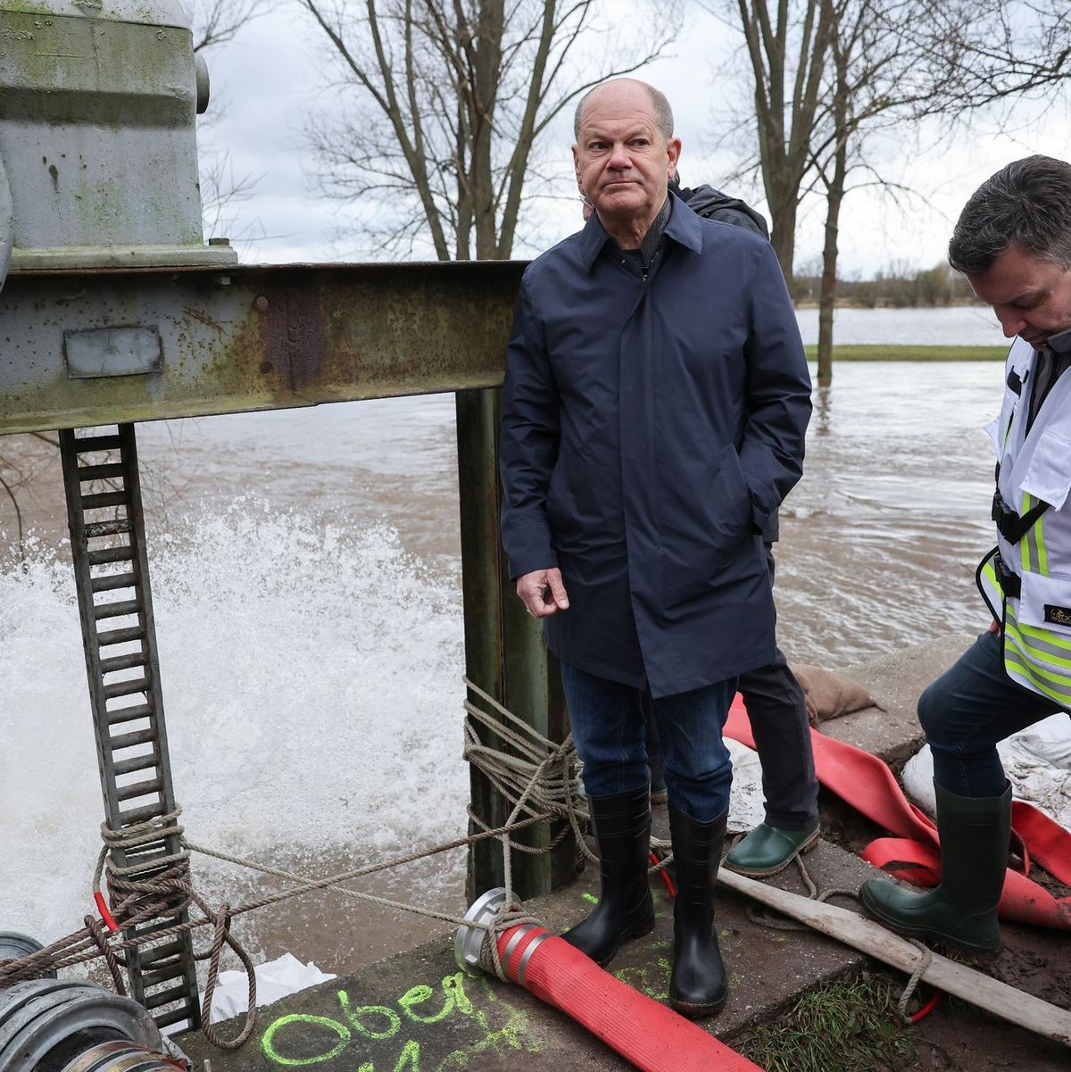 Bundeskanzler Olaf Scholz begutachtet ein Wehr in Sangerhausen. - Foto: Jan Woitas/dpa