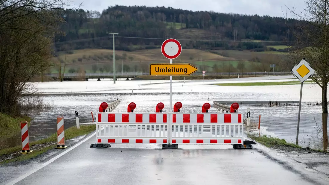 Auch der Fluss Itz führt Hochwasser. Hier eine gesperrte Straße bei Untermerzbach im Landkreis Haßberge in Bayern. - Bild: Pia Bayer/dpa