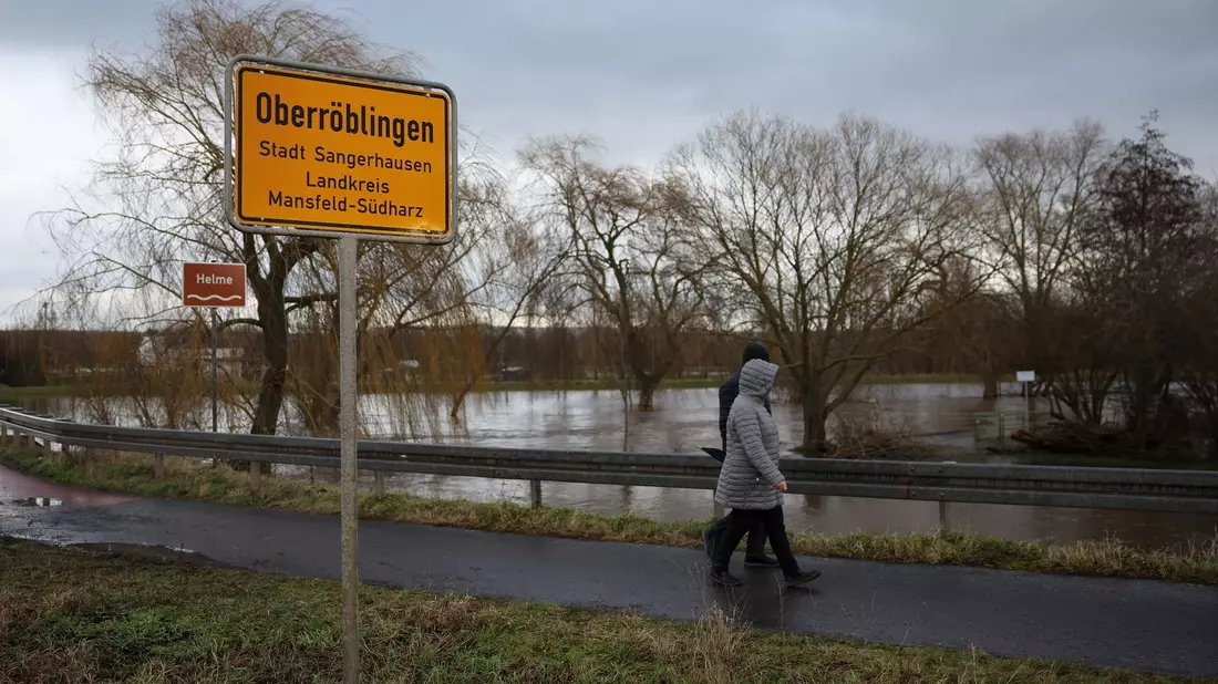 Anwohner aus Oberröblingen auf einer vom Hochwasser umschlossenen Straße. Die Lage hier bleibt weiter angespannt. - Bild: Jan Woitas/dpa