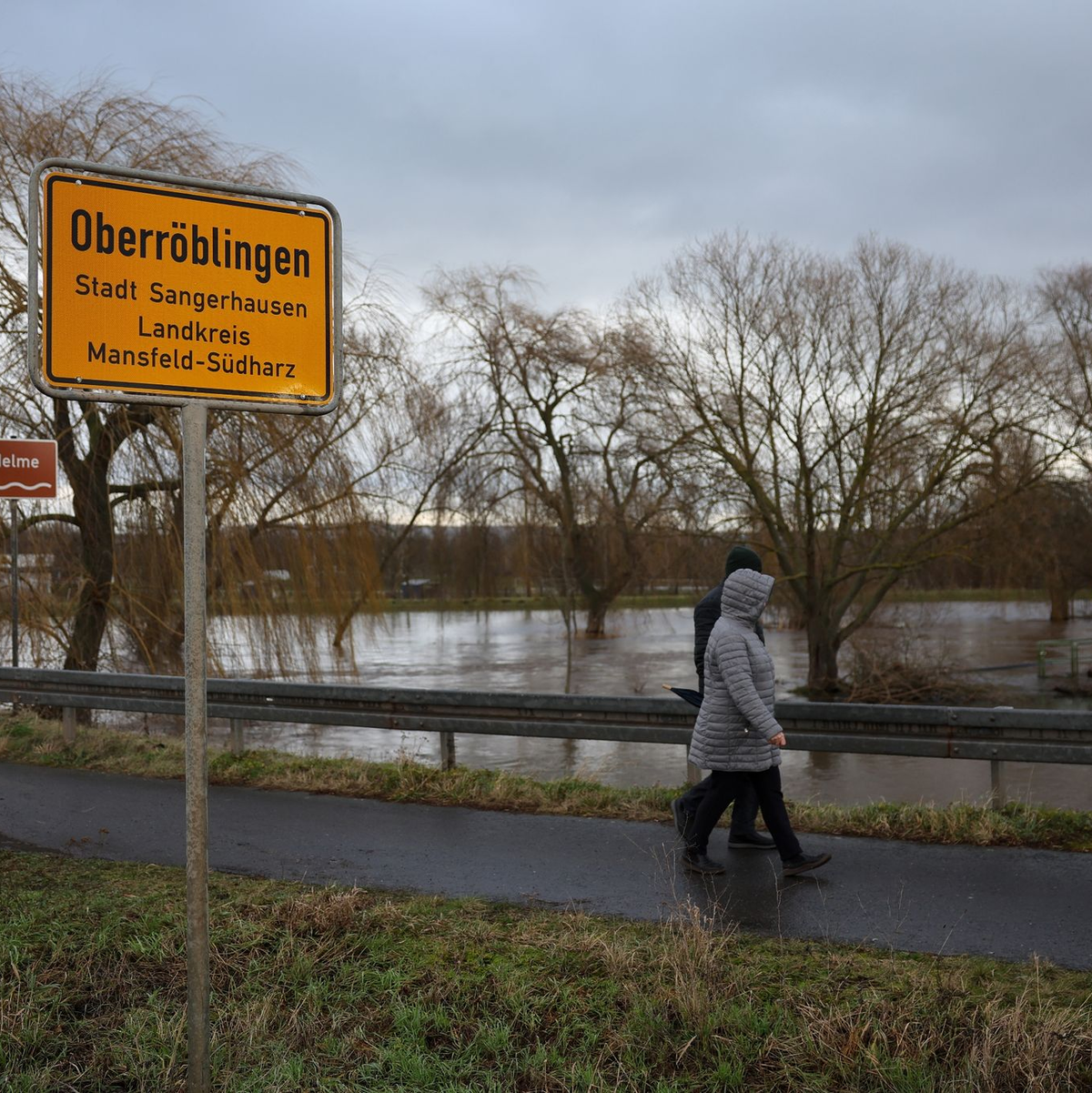 Anwohner aus Oberröblingen auf einer vom Hochwasser umschlossenen Straße. Die Lage hier bleibt weiter angespannt. - Foto: Jan Woitas/dpa