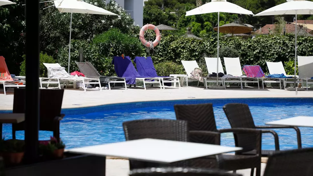 Handtücher liegen auf Sonnenliegen an einem Pool auf Mallorca. (Symbolbild) - Bild: Clara Margais/dpa
